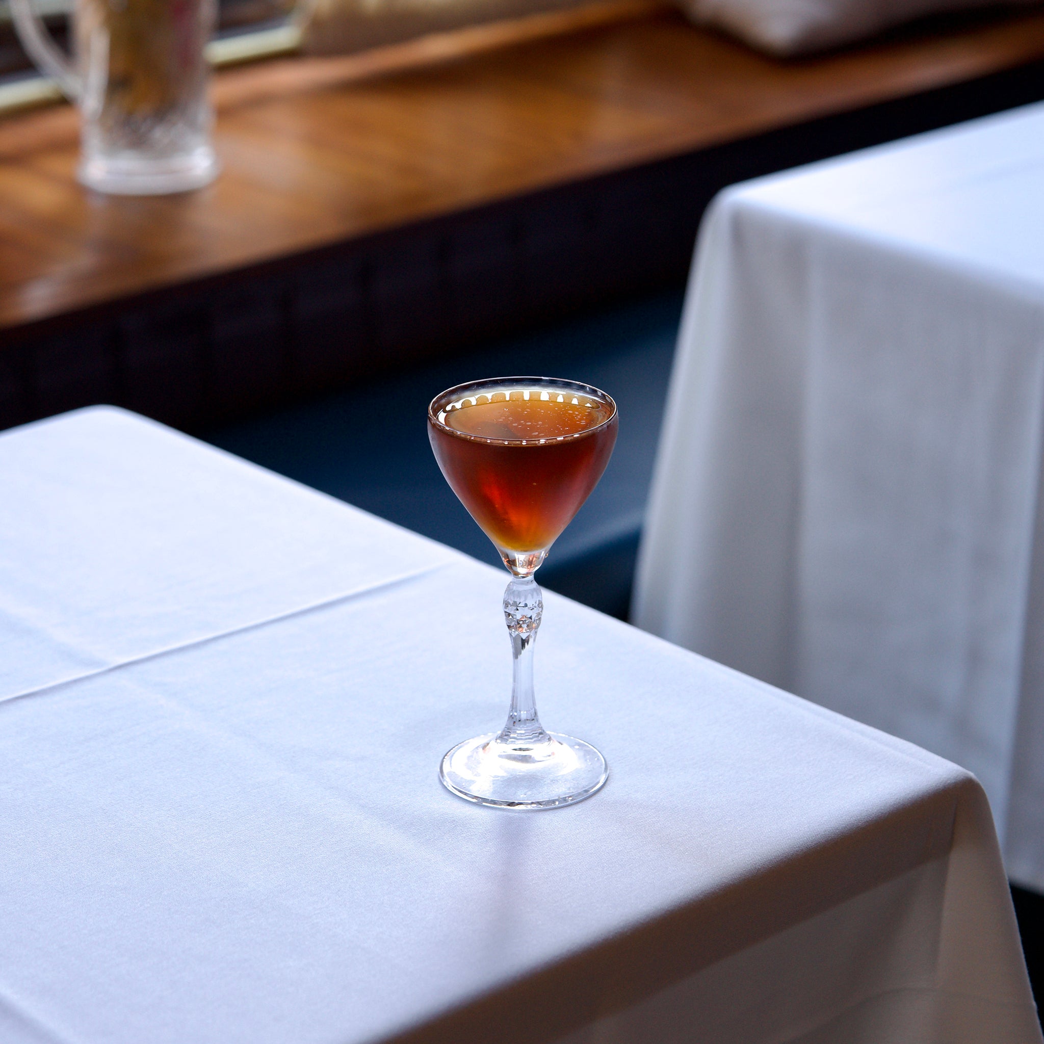 Glass of red wine on a white tablecloth with a blurred background