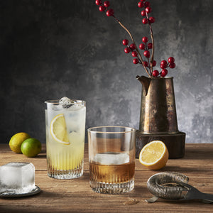 Graphics Cocktail glasses setup with lemon, lime, and ice on a wooden table.