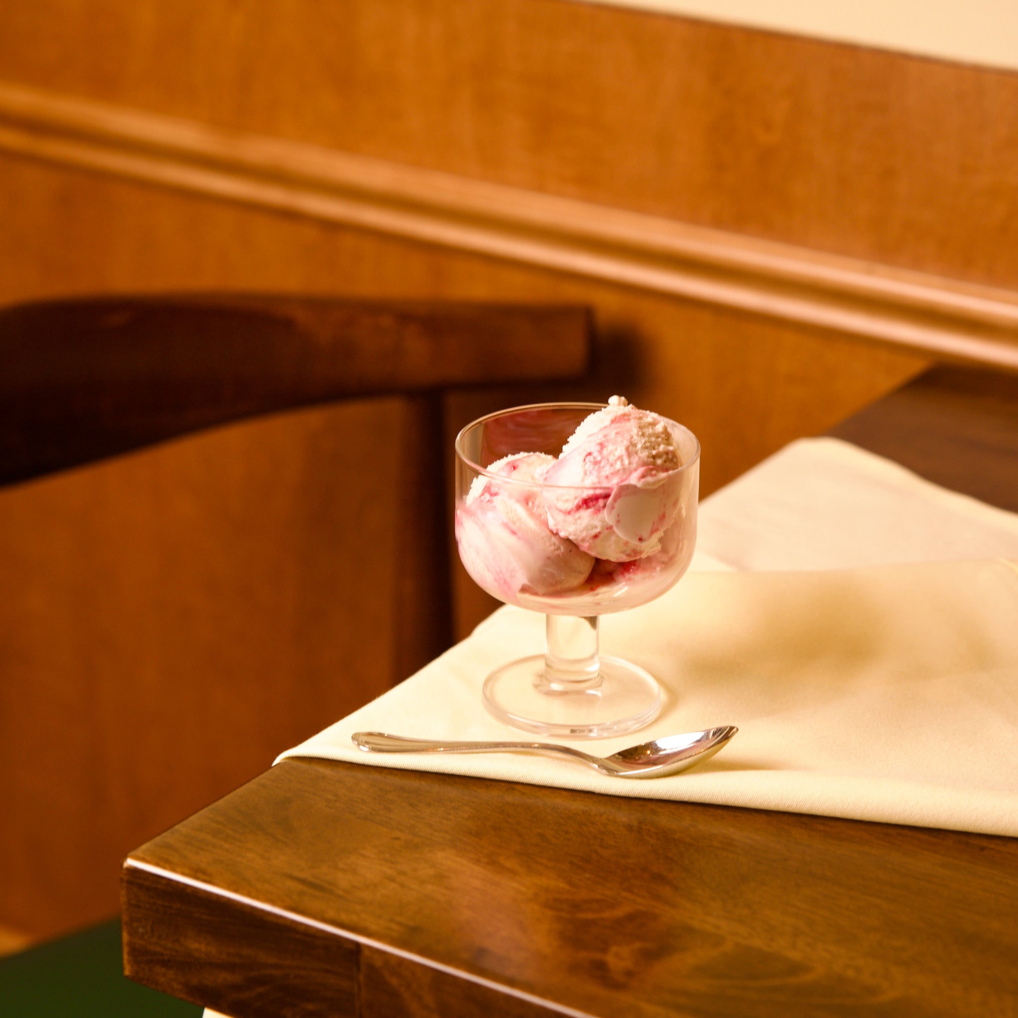 Hosteria dessert glass bowl with pink ice cream on a wooden table