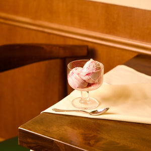 Hosteria dessert glass bowl with pink ice cream on a wooden table