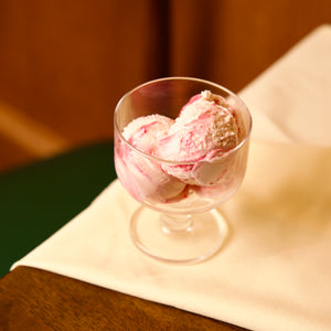 Hosteria dessert glass bowl with pink ice cream on a wooden surface