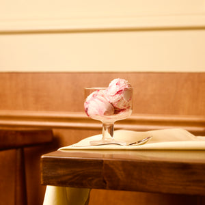 Hosteria dessert glass bowl with pink ice cream on a wooden surface