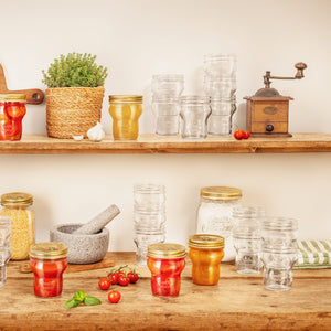 Quattro Stagioni special edition jars of preserved food on a wooden table with shelves in the background